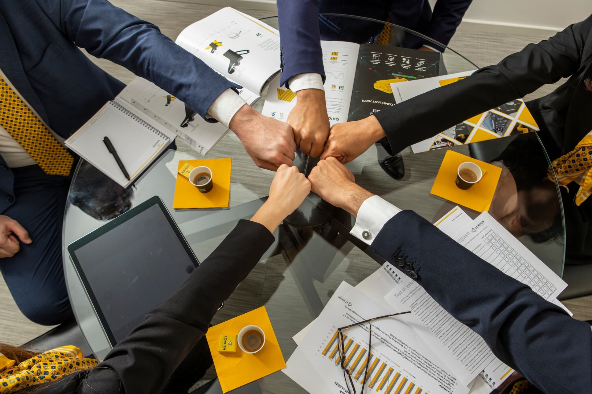 Team Lokhen Group unisce le mani attorno al tavolo riunioni